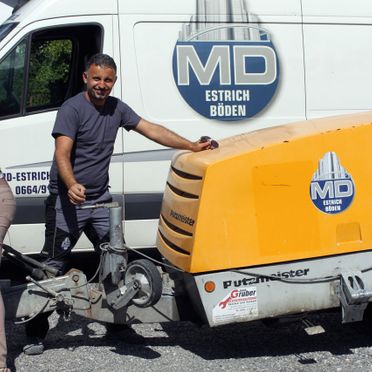 Ein Mitarbeiter beim Transport des Estrichmischers